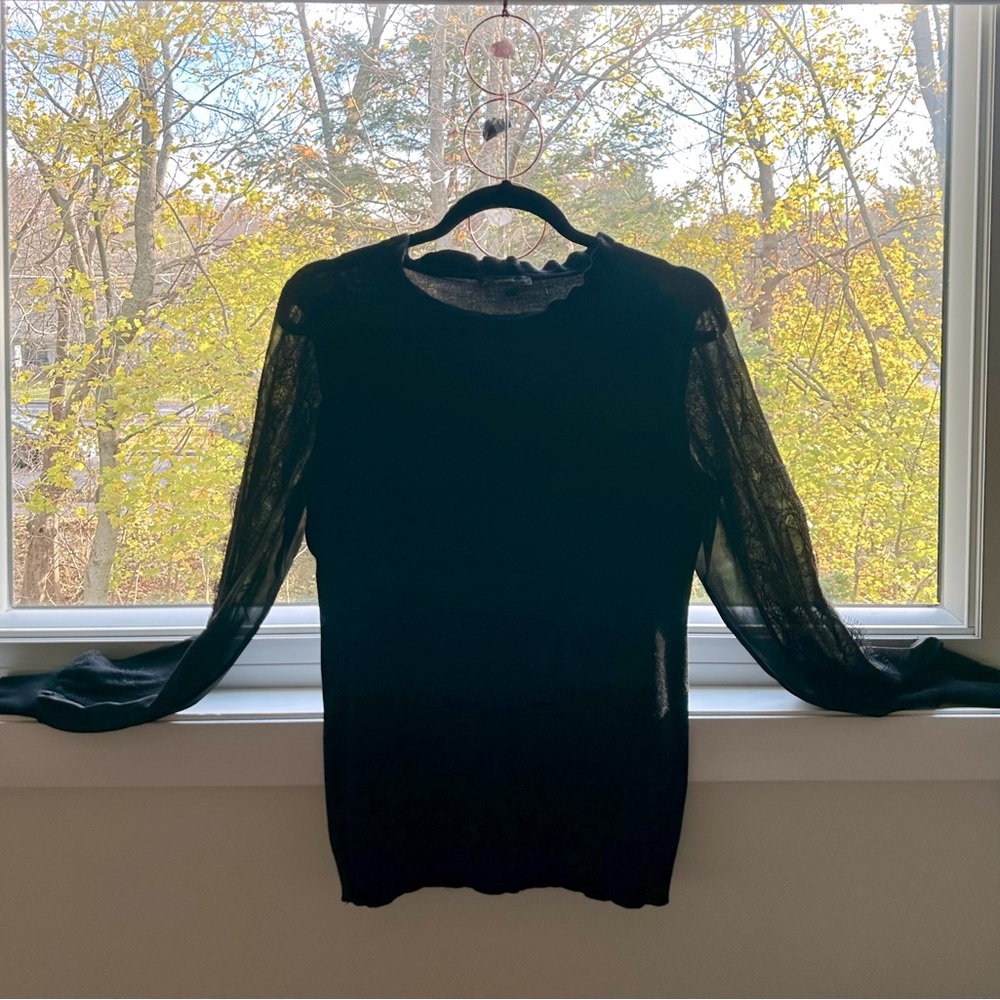 Women’s black, light weight sweater blouse with lace-detailed sheer sleeves.
